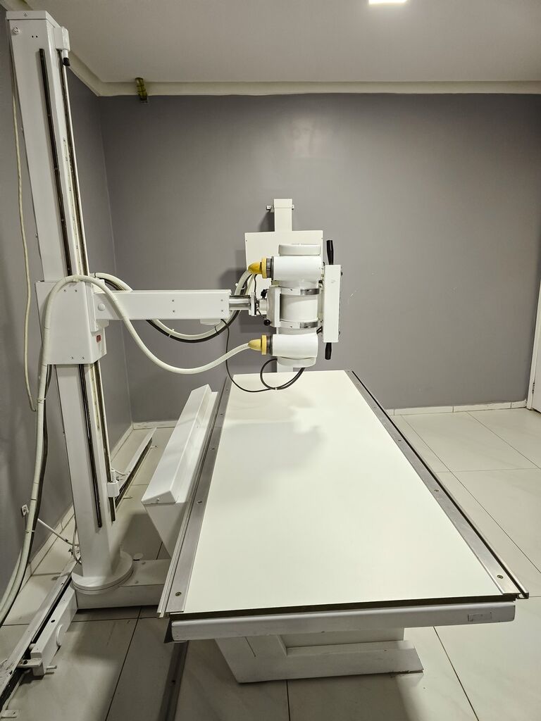 Aparelho de raio-X médico com o tubo sobre a mesa radiográfica