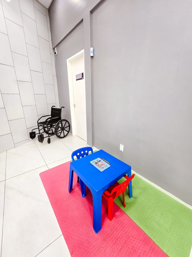 Espaço kids com mesa infantil e cadeira de rodas disponível para pacientes