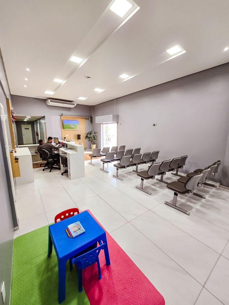 Recepção e sala de espera com o espaço kids, mesinha infantil e tapete colorido