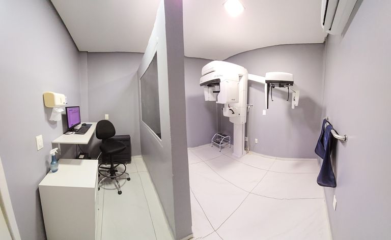 Sala de radiografia panorâmica odontológica com estação de trabalho e cabine técnica