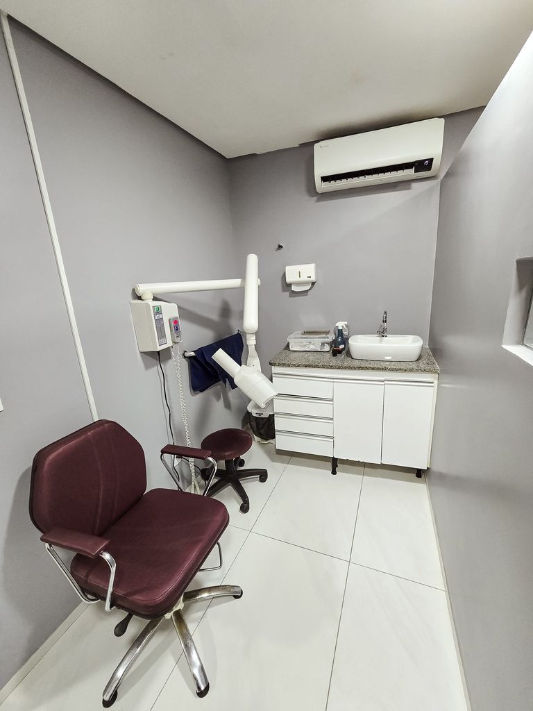 Sala de radiografia periapical com cadeira e aparelho de raios X odontológico