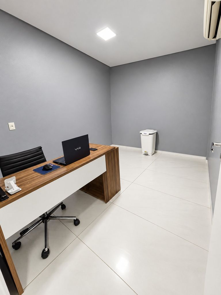 Sala de atendimento sem maca, com mesa, cadeira e ar-condicionado